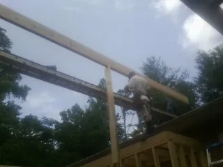 Carpenter setting a ridge beam over a new addition frame — Ice Dam Removal by Roofing Brothers in Eagle Springs
