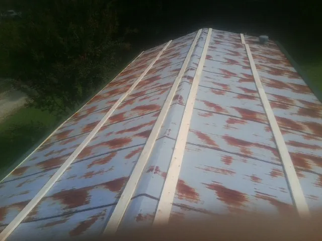 Rusted metal roof panels with new wood purlins before replacement — Storm Damage Roof Repair in Eagle Springs by Roofing Brothers