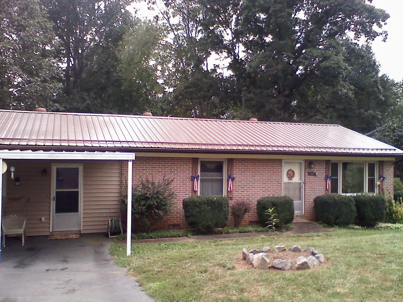 Bronze metal roof and carport on a brick ranch home — Roof Repair work by our crew in Eagle Springs